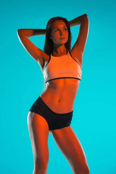 Muscular young woman athlete posing at studio — Stock Photo, Image