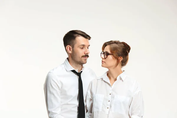 O homem de negócios e mulher se comunicando em um fundo cinza — Fotografia de Stock