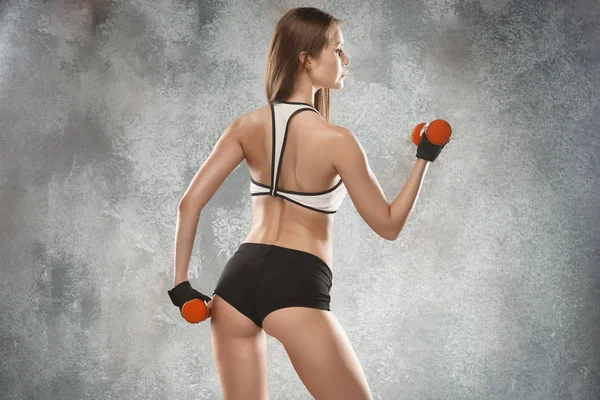 Muscular young woman athlete posing at studio — Stock Photo, Image