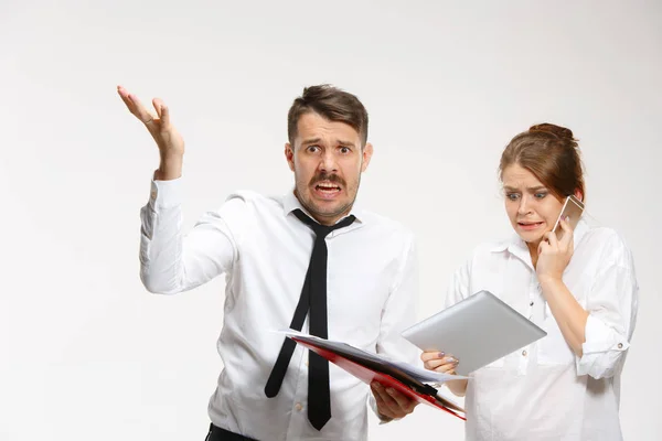 El hombre y la mujer de negocios que se comunican sobre un fondo gris — Foto de Stock