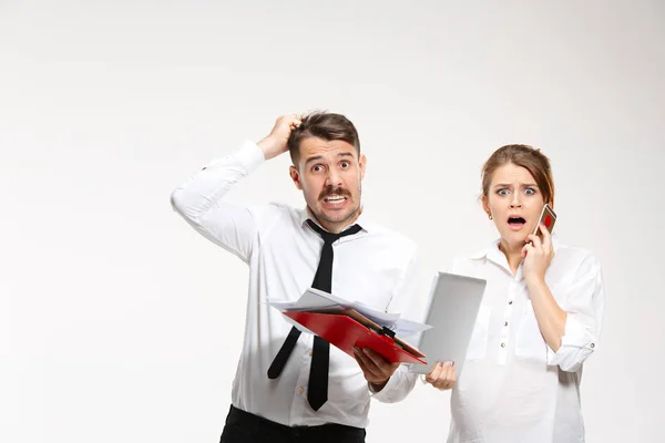 El hombre y la mujer de negocios que se comunican sobre un fondo gris — Foto de Stock