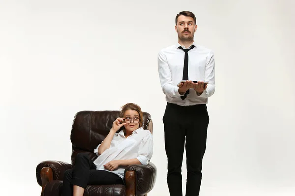 Молодой человек и красивая женщина в деловом костюме в офисе на белом фоне — стоковое фото