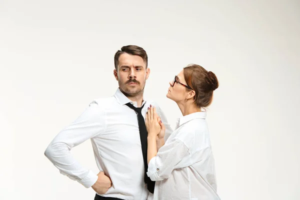 Der junge Mann und die schöne Frau im Business-Anzug im Büro auf weißem Hintergrund — Stockfoto