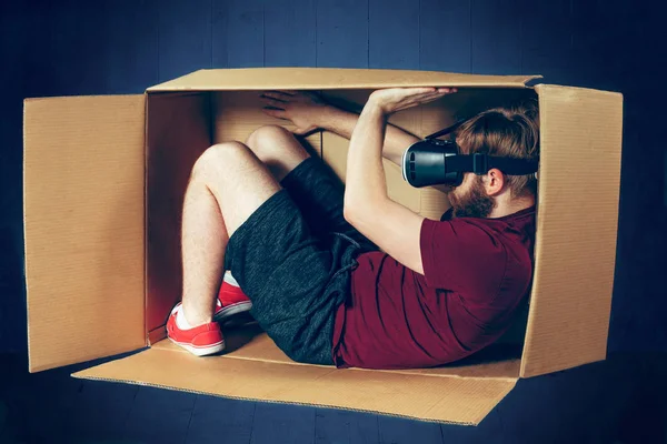 Conceito introvertido. O homem sentado dentro da caixa com óculos de realidade virtual. Conceito de tecnologia futura — Fotografia de Stock