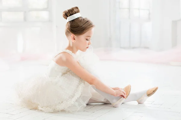 A pequena balerina em tutu branco na aula na escola de balé — Fotografia de Stock