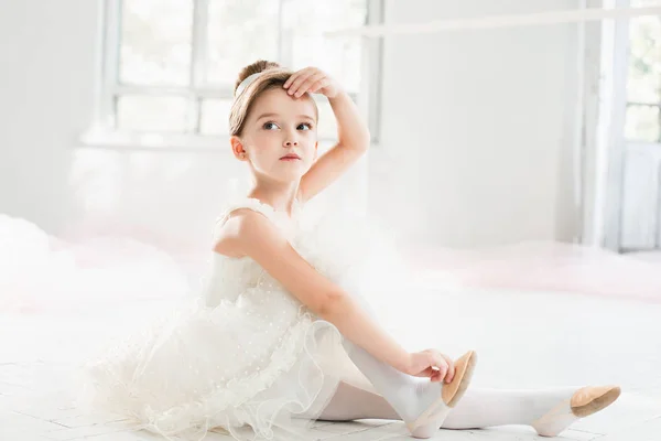 Маленька балерина в білому навчанні на уроках балетної школи — стокове фото