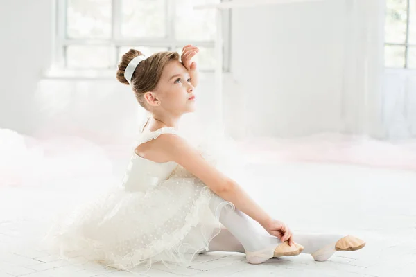 A pequena balerina em tutu branco na aula na escola de balé — Fotografia de Stock