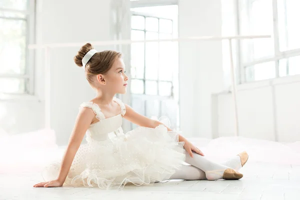 A pequena balerina em tutu branco na aula na escola de balé — Fotografia de Stock