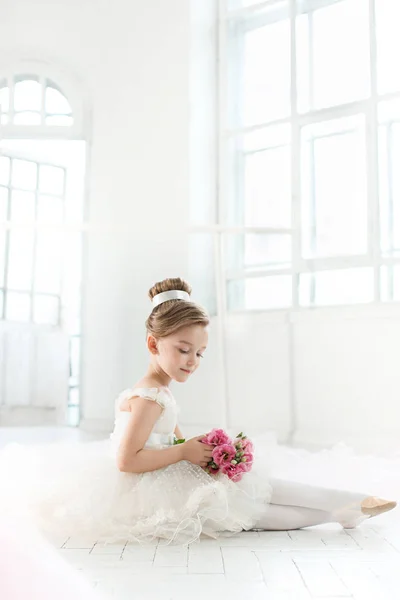 A pequena balerina em tutu branco na aula na escola de balé — Fotografia de Stock