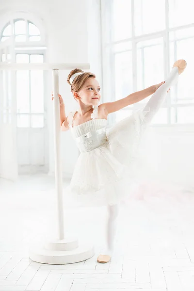 Piccola ballerina in tutù. Adorabile bambino che danza balletto classico in uno studio bianco . — Foto Stock