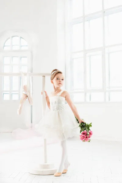 Uma bailarina em tutu. Adorável criança dançando balé clássico em um estúdio branco . — Fotografia de Stock