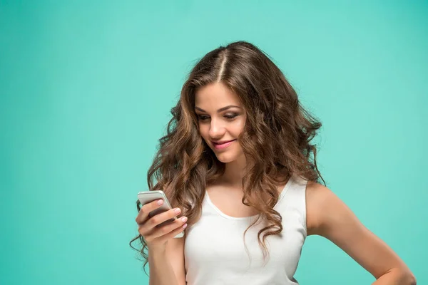 Mujer impactada mirando el teléfono móvil sobre fondo verde — Foto de Stock