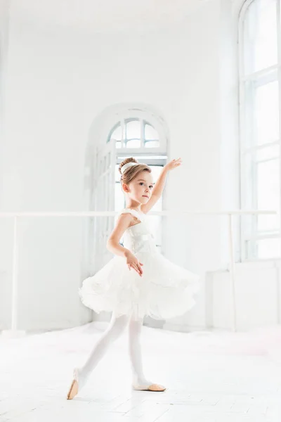 Piccola ballerina in tutù. Adorabile bambino che danza balletto classico in uno studio bianco . — Foto Stock