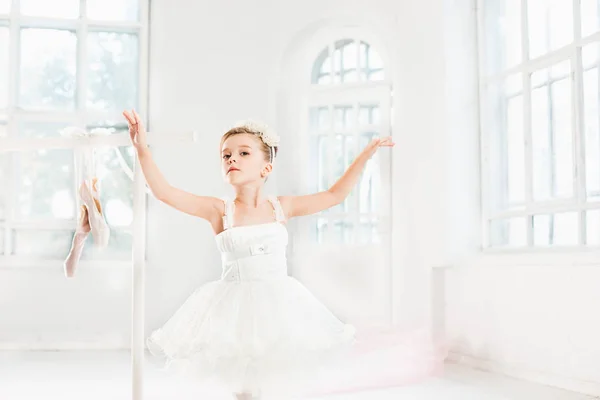 Uma bailarina em tutu. Adorável criança dançando balé clássico em um estúdio branco . — Fotografia de Stock