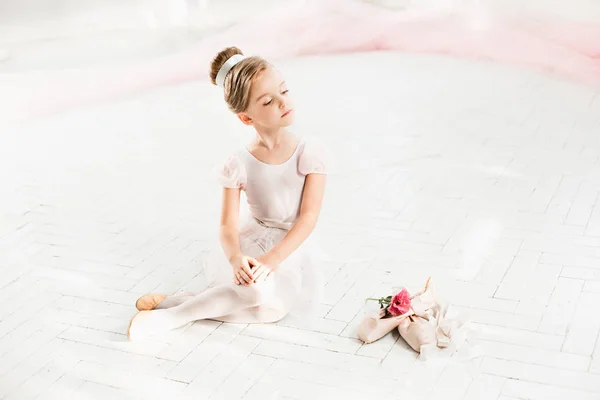 Маленькая балерина в белой пачке в классе в балетной школе — стоковое фото