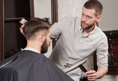 Genç yakışıklı Kuaför berber içinde çekici adamın saç kesimi yapma