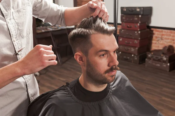 Les mains de coiffeur faisant coupe de cheveux au jeune homme dans le salon de coiffure — Photo