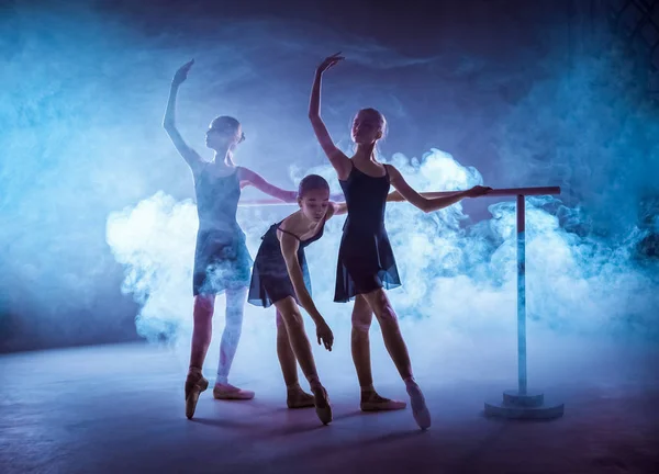 Les jeunes ballerines qui s'étirent sur le bar — Photo