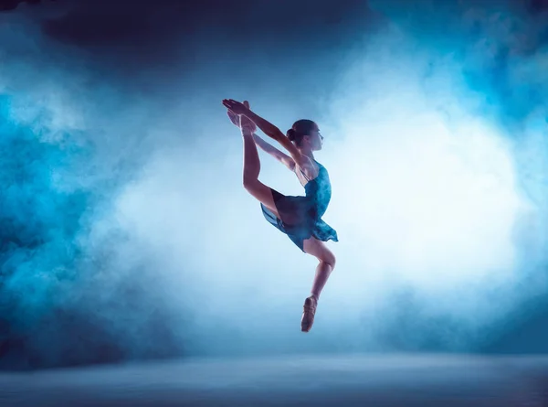 Bela jovem bailarina de balé pulando em um fundo lilás . — Fotografia de Stock