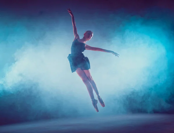 Bela jovem bailarina de balé pulando em um fundo lilás . — Fotografia de Stock