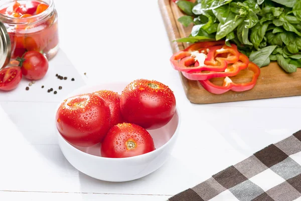 Canned tomatoes and fresh tomato on white background