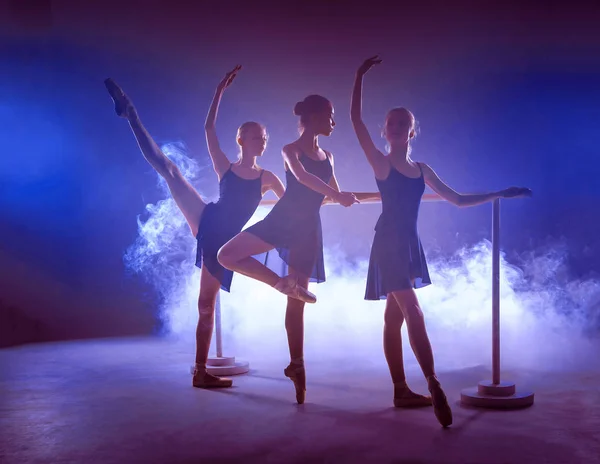 Молодые балерины, растянувшиеся на стойке — стоковое фото