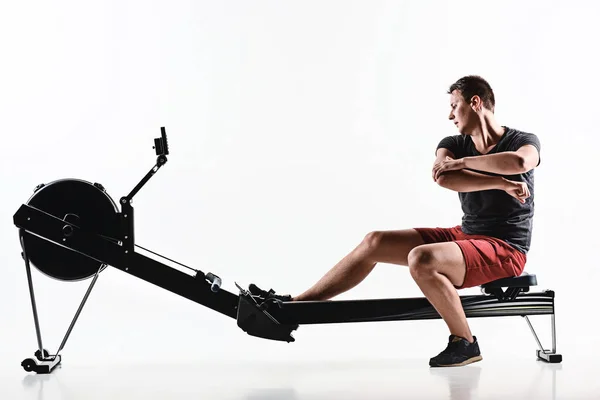 Ο άνθρωπος χρησιμοποιώντας μια μηχανή τύπου στο γυμναστήριο. — Φωτογραφία Αρχείου