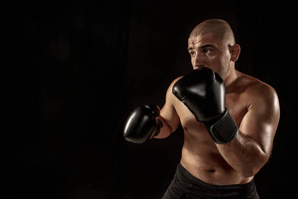 The young man kickboxing on black — Stock Photo, Image