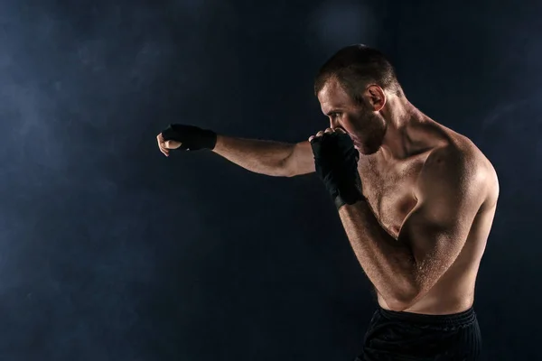 Le jeune homme kickboxing sur noir — Photo