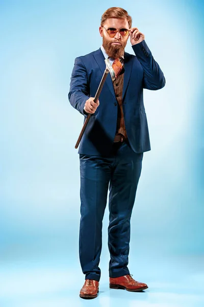 Barded muž v obleku drží hůl. — Stock fotografie