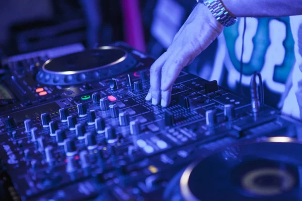 DJ tocando música en el mezclador sobre fondo borroso colorido — Foto de Stock