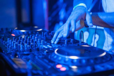 DJ rengarenk bulanık arkaplanda mikserde müzik çalıyor