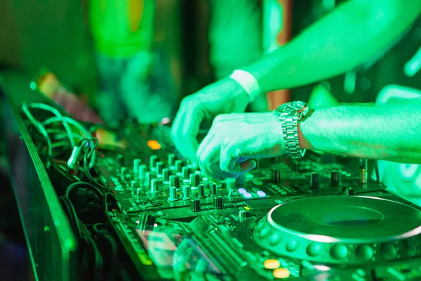 DJ tocando música en el mezclador sobre fondo borroso colorido — Foto de Stock