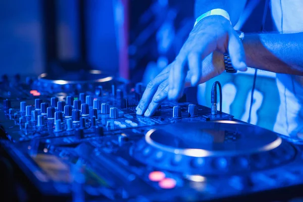 DJ tocando música en el mezclador sobre fondo borroso colorido —  Fotos de Stock