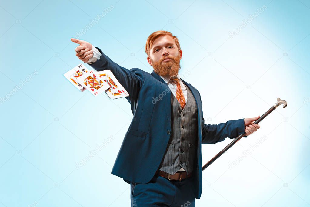 The barded man in a suit holding cane.