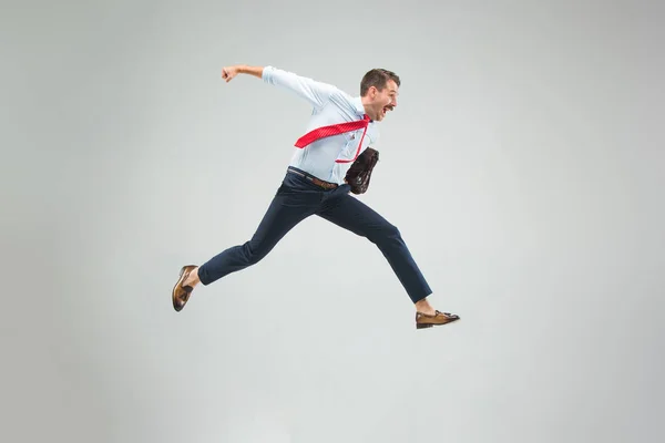 Empresario corriendo con un maletín, aislado sobre fondo gris — Foto de Stock