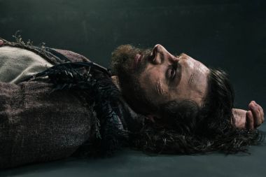 Cadılar Bayramı zombi asfalt parke üzerinde yalan. Vampir hippi kırmızı kan açık havada. Tatil kutlama kavramı. Adam kanlı sakal ve saç.