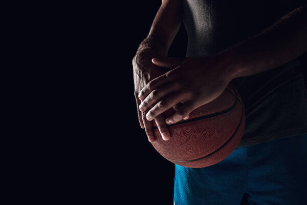 The hands of a basketball player with ball