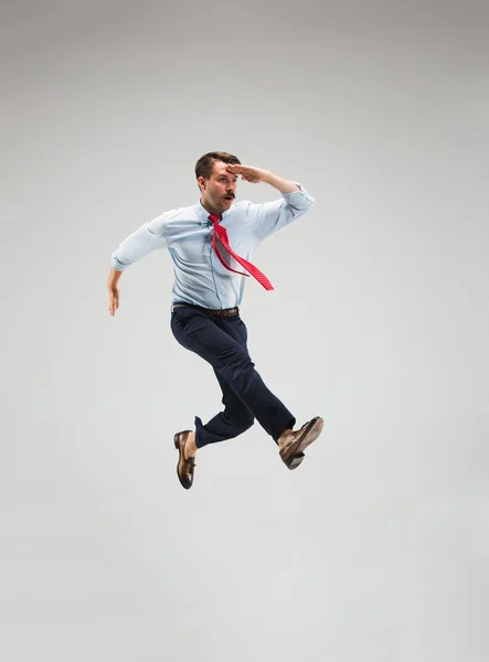 Empresário correndo em fundo cinza — Fotografia de Stock