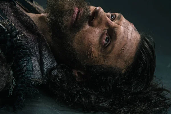 Cadılar Bayramı zombi asfalt parke üzerinde yalan. Vampir hippi kırmızı kan açık havada. Tatil kutlama kavramı. Adam kanlı sakal ve saç.