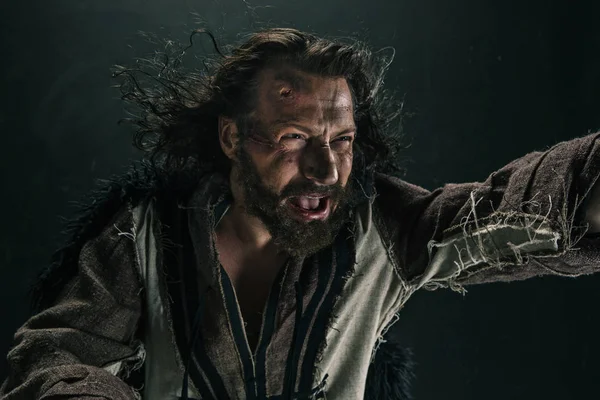 Siyah bir arka plan karşı poz bir savaş posta acımasız bir kel viking portresi.