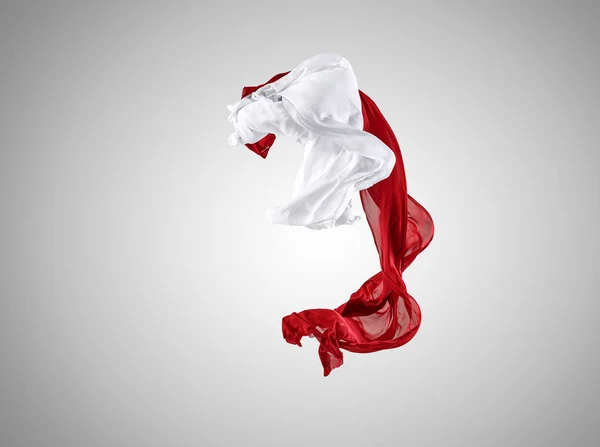 Hladká elegantní transparentní červené a bílé látky oddělené na šedém pozadí. — Stock fotografie