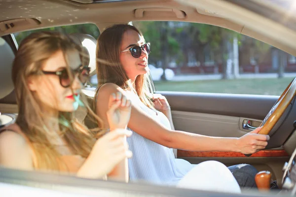 Mujeres jóvenes en el coche sonriendo — Foto de Stock