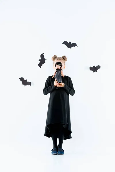 Kislány boszorkány a fekete ruha alatt mágikus tartozékok. Halloween, a stúdió este. — Stock Fotó