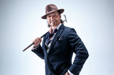 Genç portre studio gri arka plan üzerinde şapkalı adam.