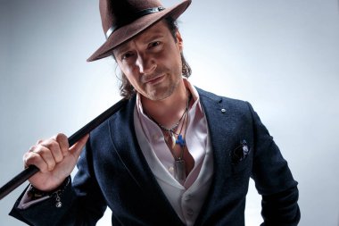 Baston tutan bir takim elbisesi ve olgun adam.