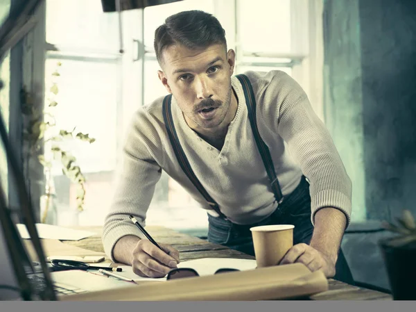 Ofisteki çizim masasında çalışan mimar