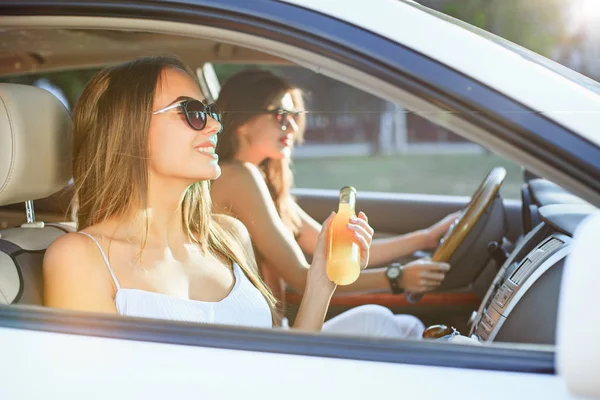 Las jóvenes en el coche sonriendo — Foto de Stock