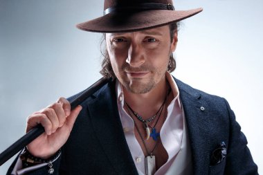 Baston tutan bir takim elbisesi ve olgun adam.