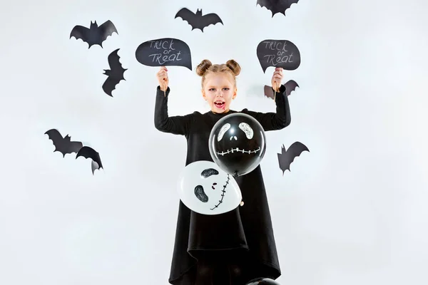 Niña bruja en vestido negro sobre accesorios mágicos. Halloween, la noche del estudio . — Foto de Stock